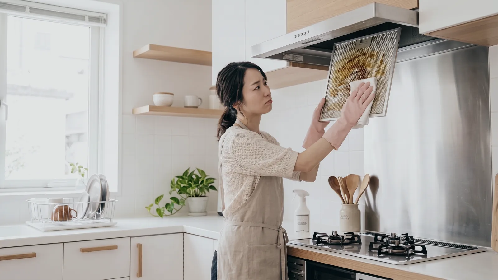 レンジフードのフィルターの油汚れに困る女性